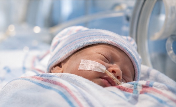 Newborn resting in a neonatal care setting
